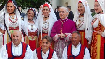 Erzbischof Sanna zwischen Leuten in der Tracht von Oristano